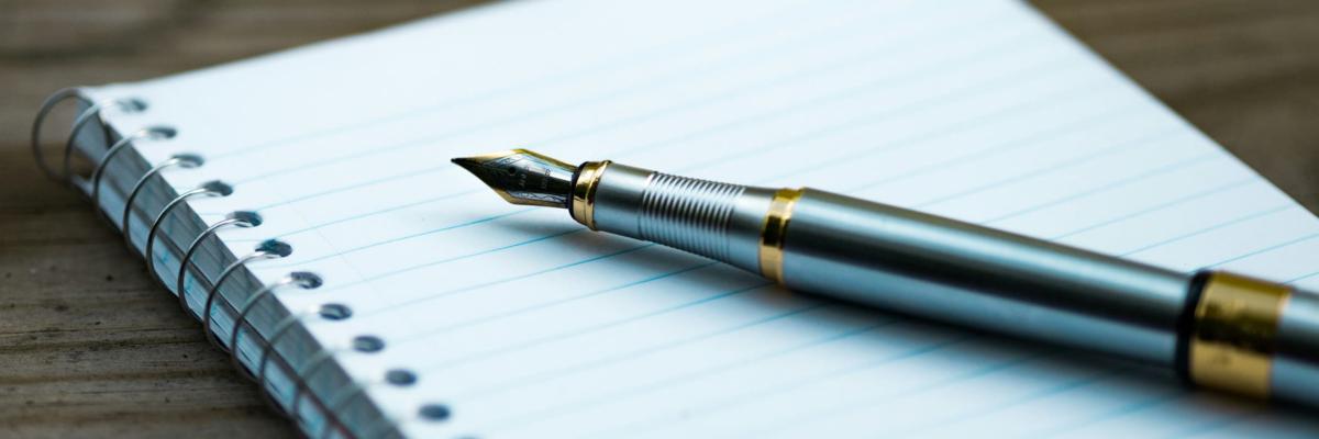 A fountain pen on a notepad.